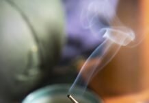 Beginner’s Guide to Zen Living and Meditation a cracked and slightly deflated zafu meditation cushion with visible stitching coming undone, a half-burned stick of incense leaning precariously